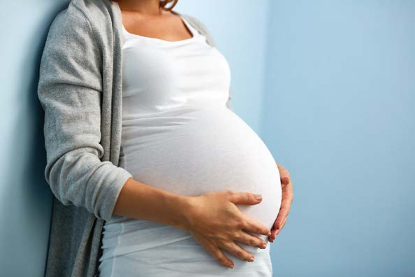Expecting mother resting a hand on her belly